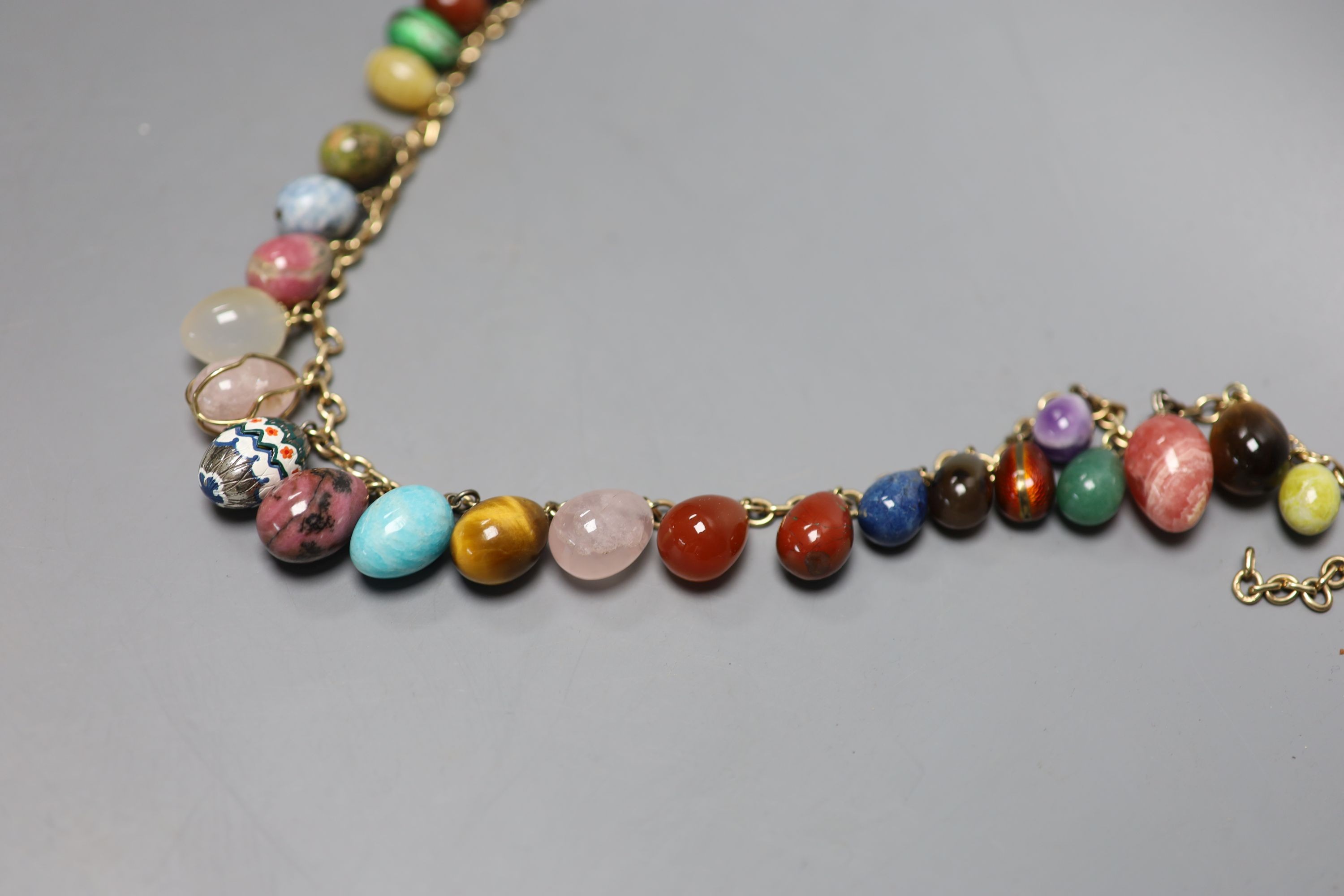 A 9ct gold and egg shaped specimen hardstone and enamelled charm set necklace, 70cm, gross weight 198.6 grams.